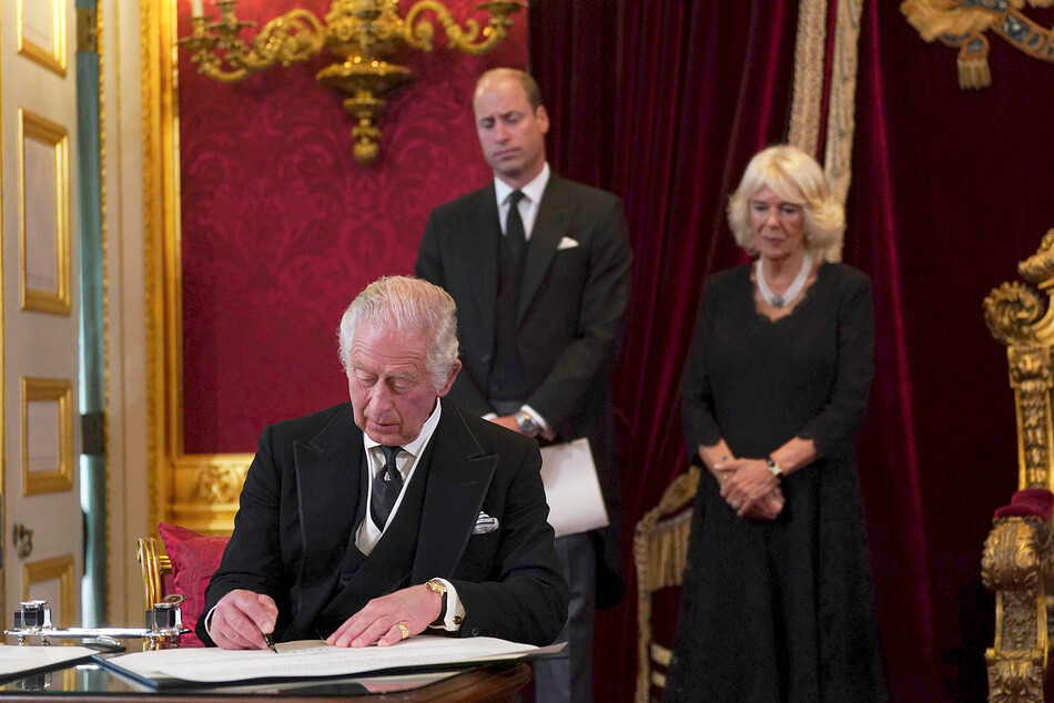 Принц Чарльз в присутствии принца Уильяма и герцогини Корнуолльской, Камиллы, а также представителей британского истеблишмента и государственных представителей королевства подписывает пакт о вступлении в должность короля Великобритании, Карла III 10 сентября 2022 года, Сент-Джеймсский дворец, Лондон