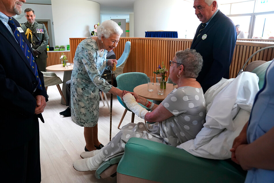 Королева Елизавета II пожимает руку пациентке Пэт Уайт во время официального открытия нового здания хосписа Thames в Мейденхеде, графство Беркшир, 15 июля 2022 года
