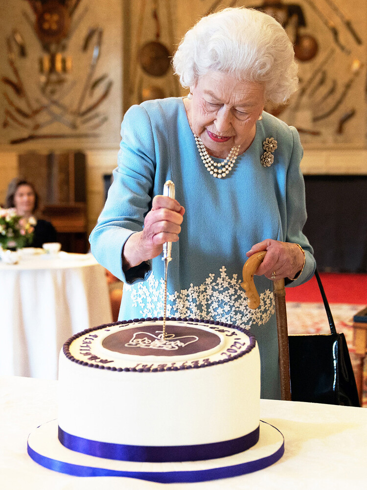 Королева Великобритании Елизавета II разрезает торт в честь начала Платинового юбилея во время приема в бальном зале поместья Сандрингем, резиденции королевы в Норфолке, 5 февраля 2022