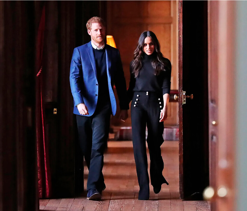 Принц Гарри и Меган Маркл идут по коридорам Холирудского дворца 13 февраля 2018 года в Эдинбурге, Шотландия