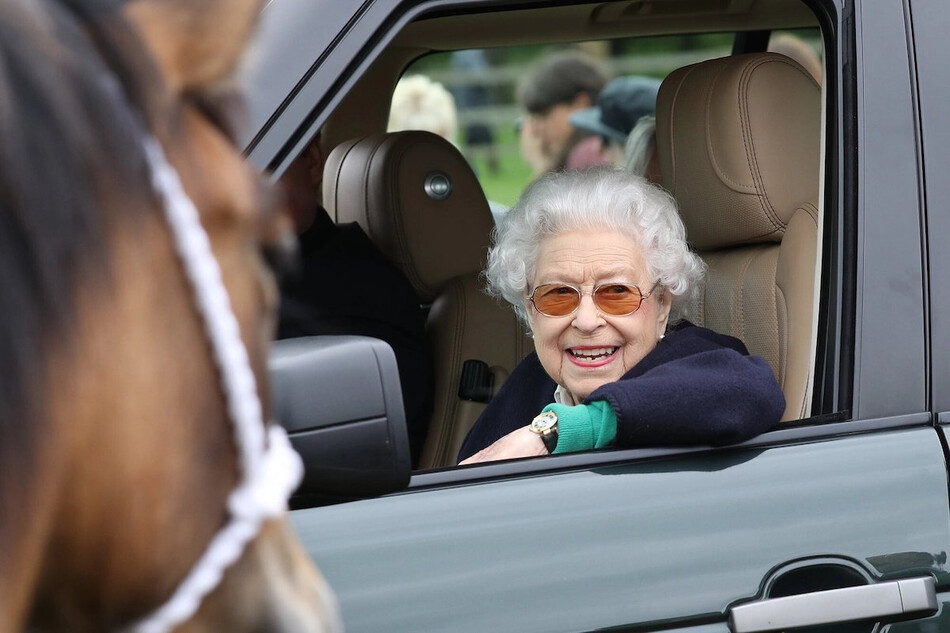 Королева Елизавета II наблюдает, сидя в своём автомобиле Range Rover с шофером, как её лошадь &laquo;Балморал Лея&raquo; соревнуется и побеждает в классе Хайленд во второй день Королевского Виндзорского конного шоу в Хоум-парке, Виндзорский замок, 13 мая 2022 года, Англия