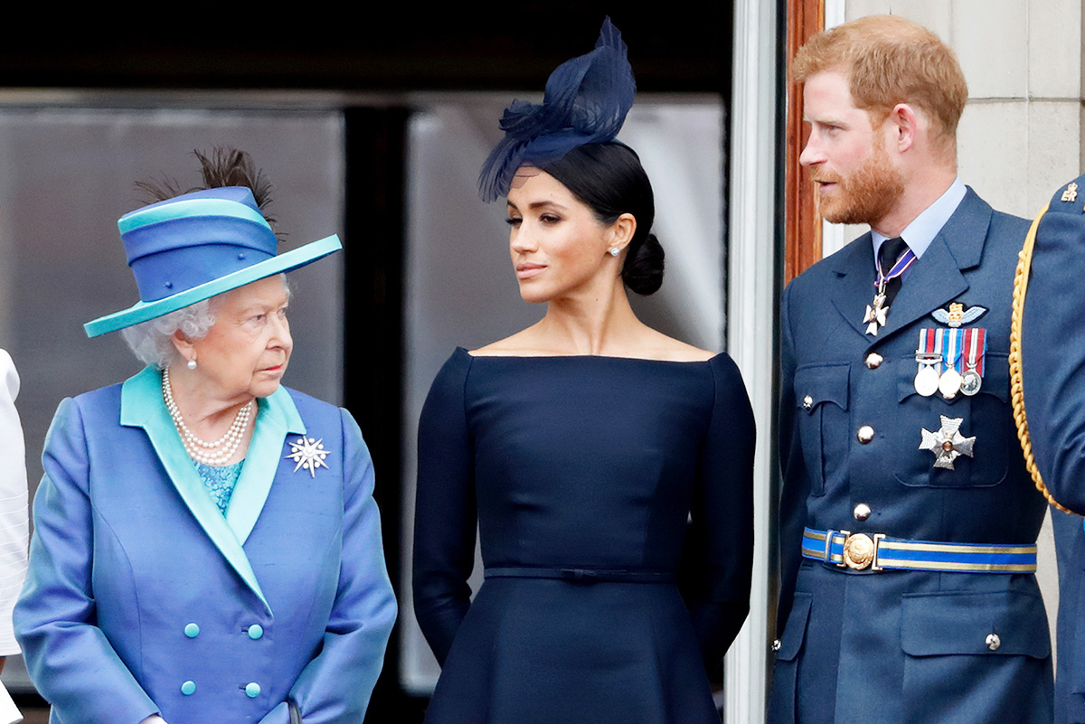 Королева Елизавета II, Меган, герцогиня Сассекская и принц Гарри, герцог Сассекский, наблюдают за парадом, посвящённым столетию королевской семьи, Букингемский дворец 10 июля 2018 года Лондон, Англия