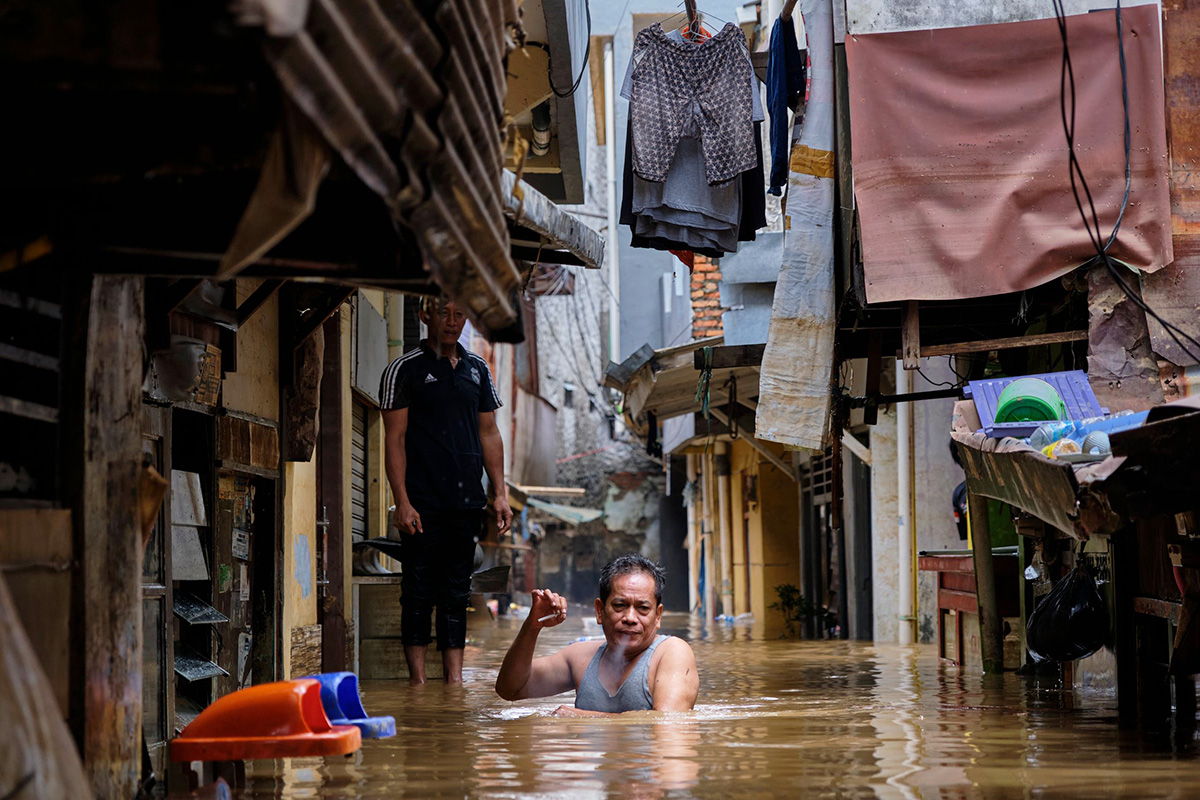 Мужчина идёт по затопленному району 2 января 2020 года в Джакарте, Индонезия