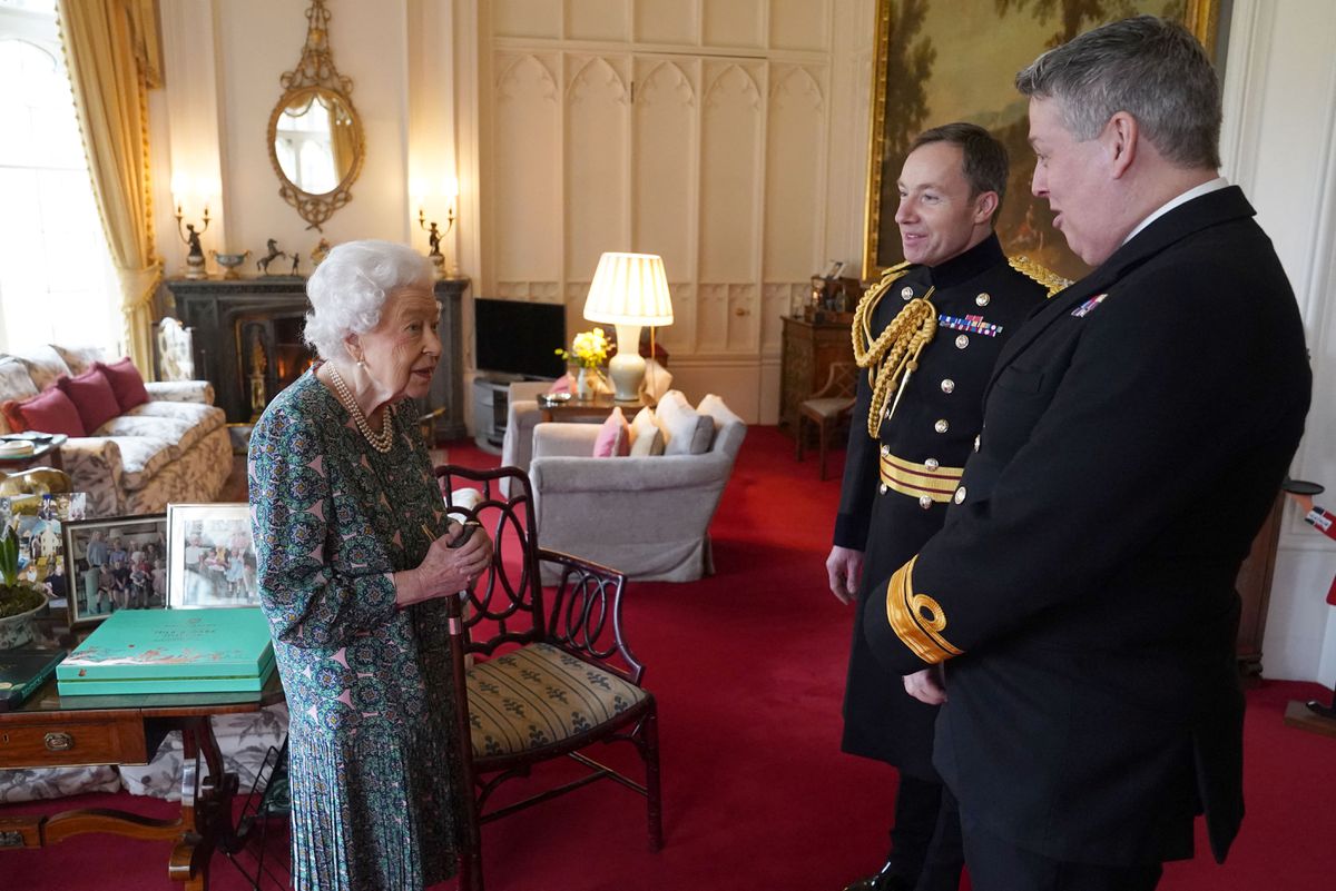Королева Елизавета II беседует с контр-адмиралом Джеймсом Маклеодом и генерал-майором Элдоном Милларом (справа) в Виндзорском замке 16 февраля 2022 года в Виндзоре, Англия