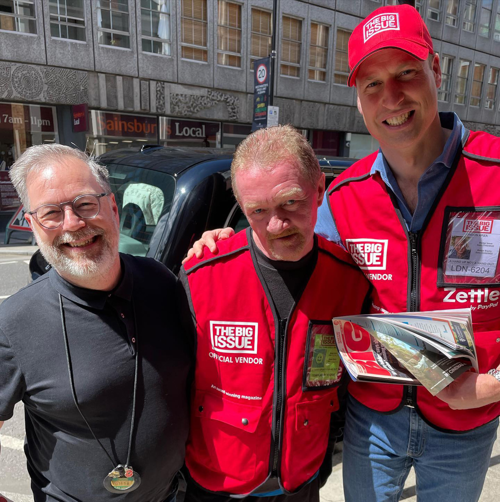 Лондонский таксист Нил Крамер (справа) с принцем Уильямом и Дэйвом Мартином, продавцом Big Issue продают социальное издание на Лондонской улице 9 июня 2022, Англия