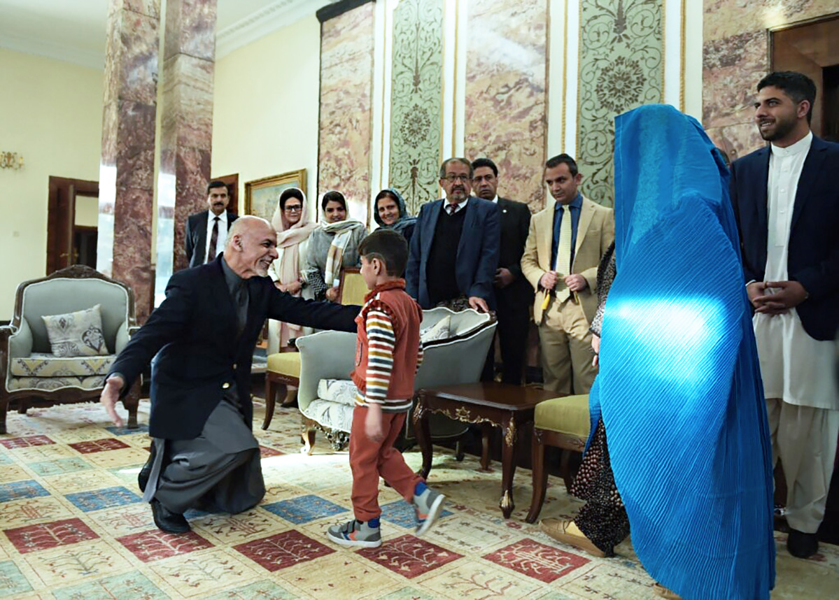 Президент Афганистана Ашраф Гани (слева) приветствует сына беженки Шарбат Гула в президентском дворце в Кабуле 9 ноября 2016 года